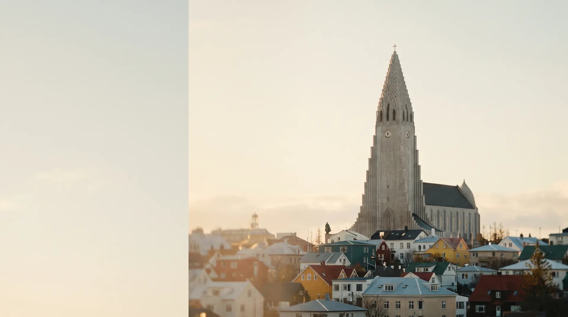 Hallgrimskirkja's concrete spire above the Reykjavik rooftops at golden hour