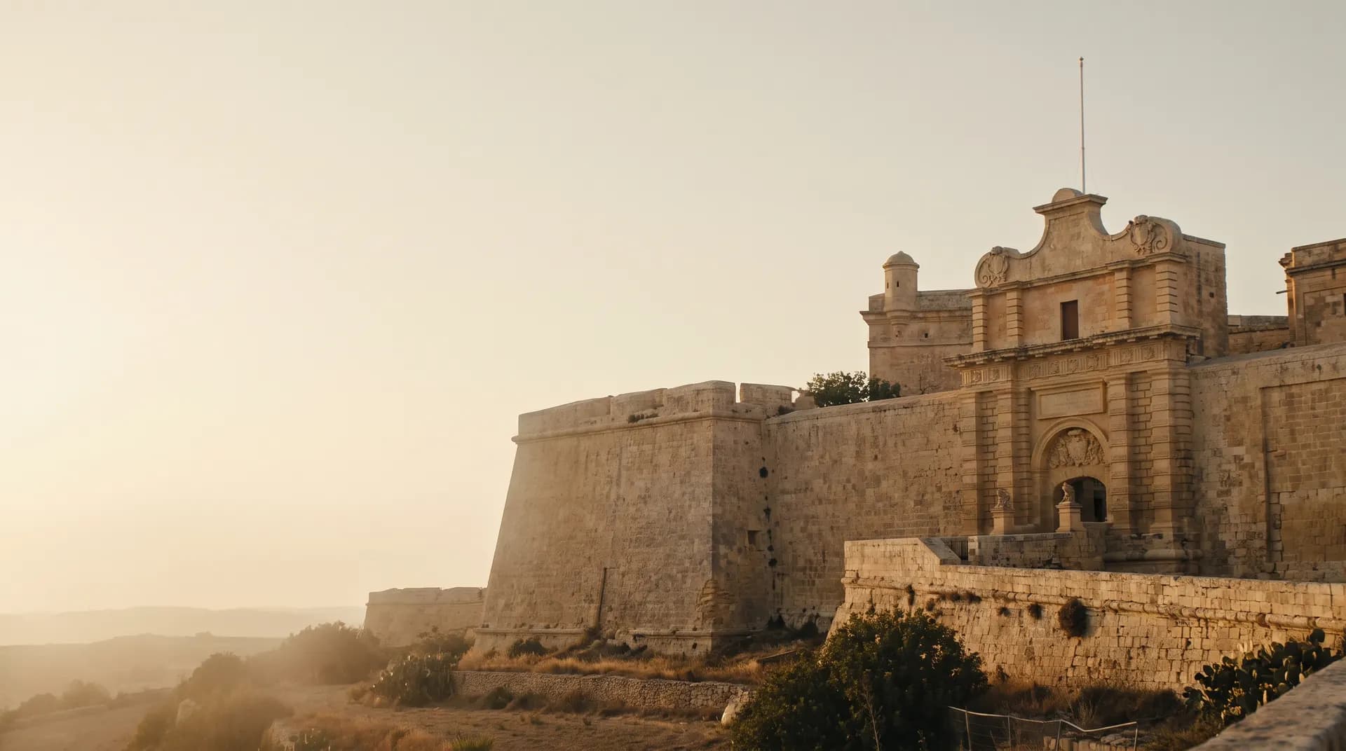 Mdina's honey-coloured stone gate and bastions at golden hour