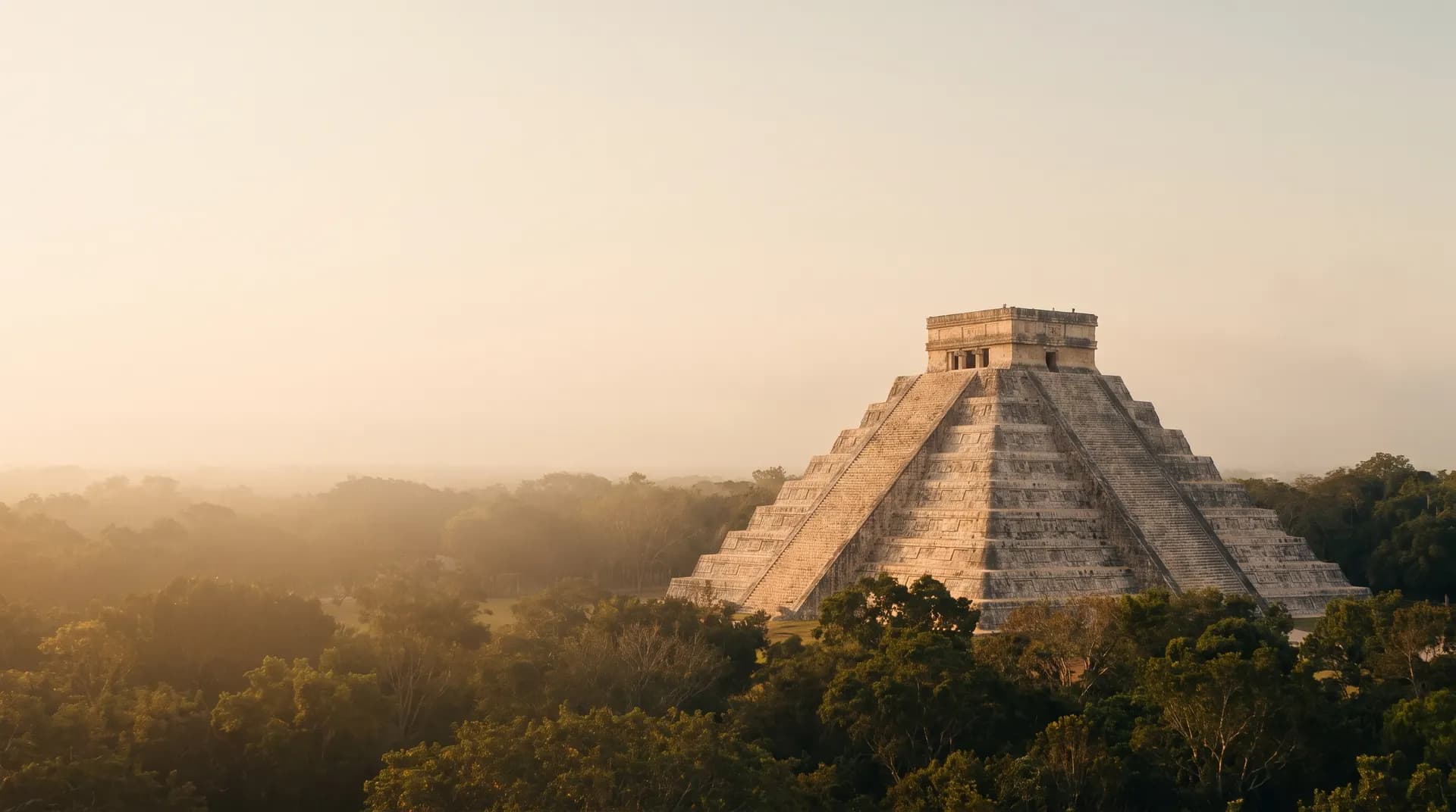 The stepped pyramid of El Castillo at Chichen Itza above the jungle canopy at golden hour