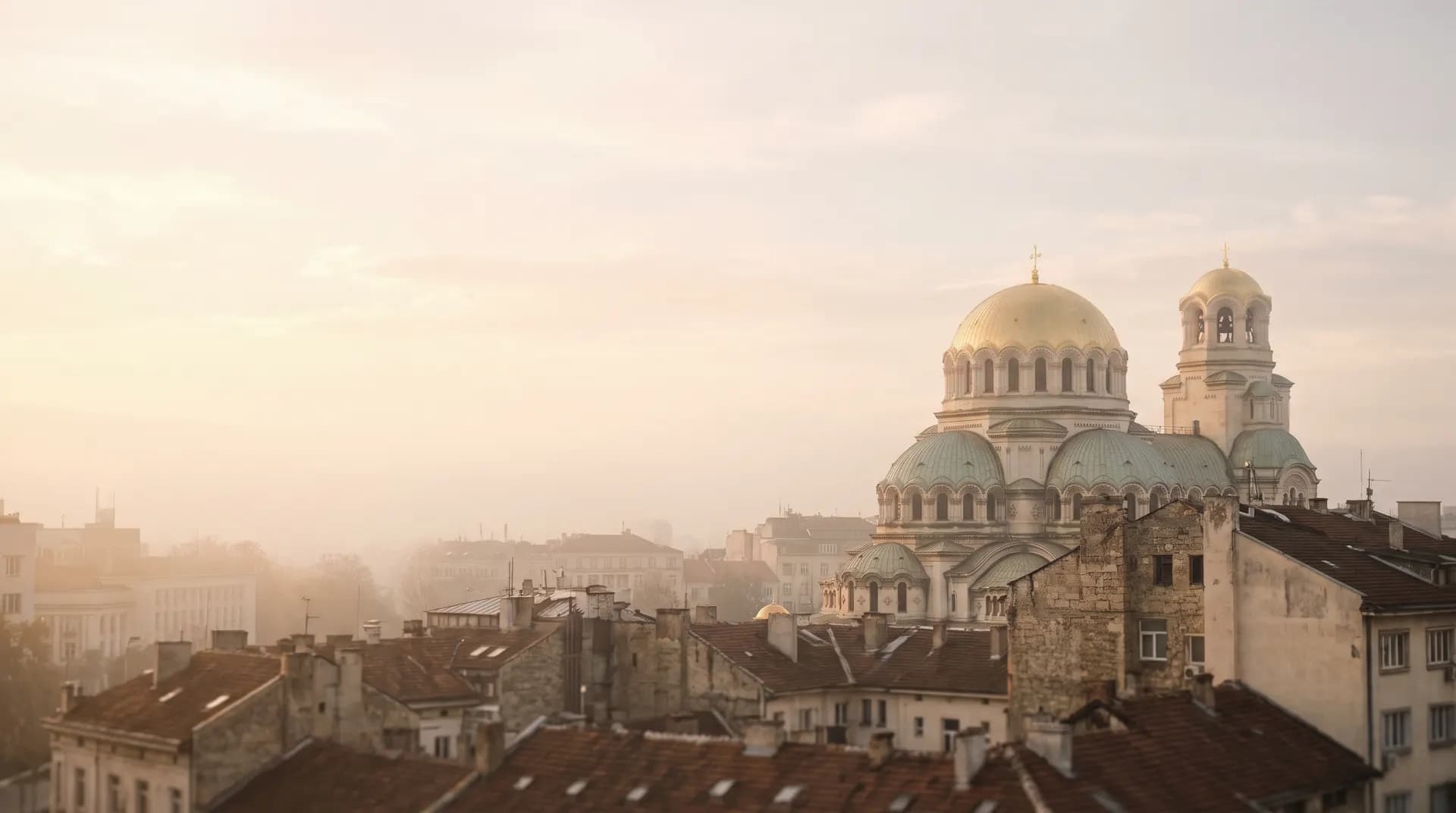 Alexander Nevsky Cathedral's golden domes above the Sofia rooftops at golden hour