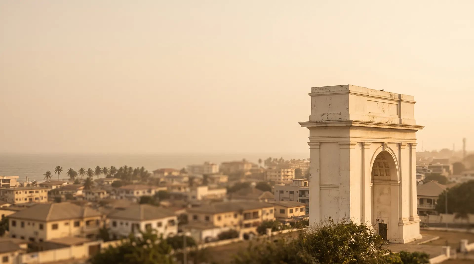The Independence Arch above hazy coastal Accra at golden hour