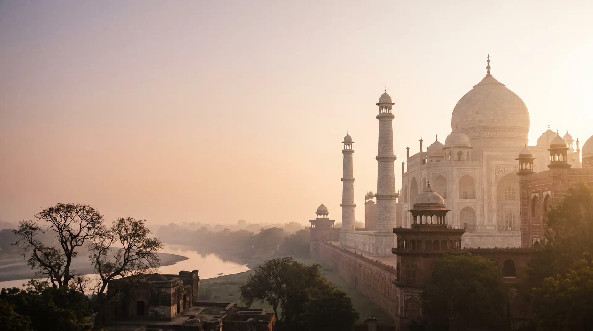 The Taj Mahal's dome and minarets above the Yamuna river at dawn