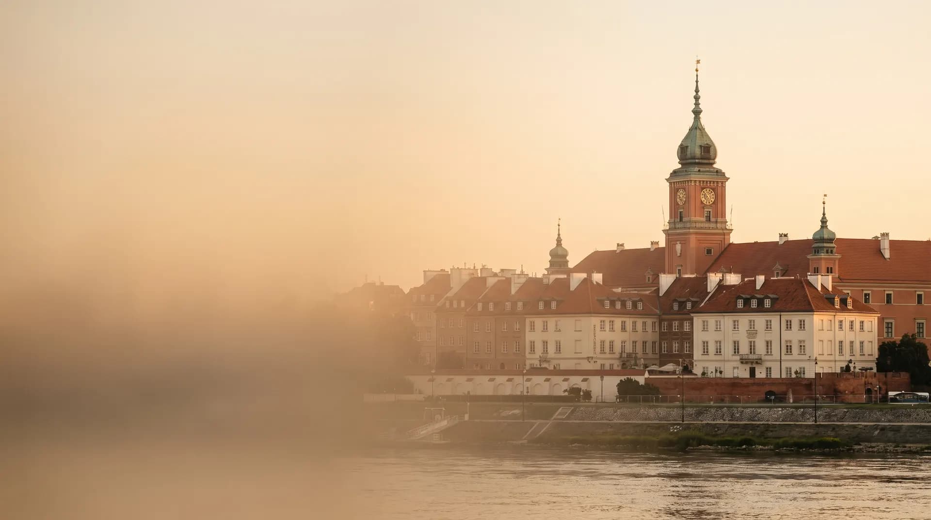 The Royal Castle and Warsaw's old town beside the Vistula at golden hour