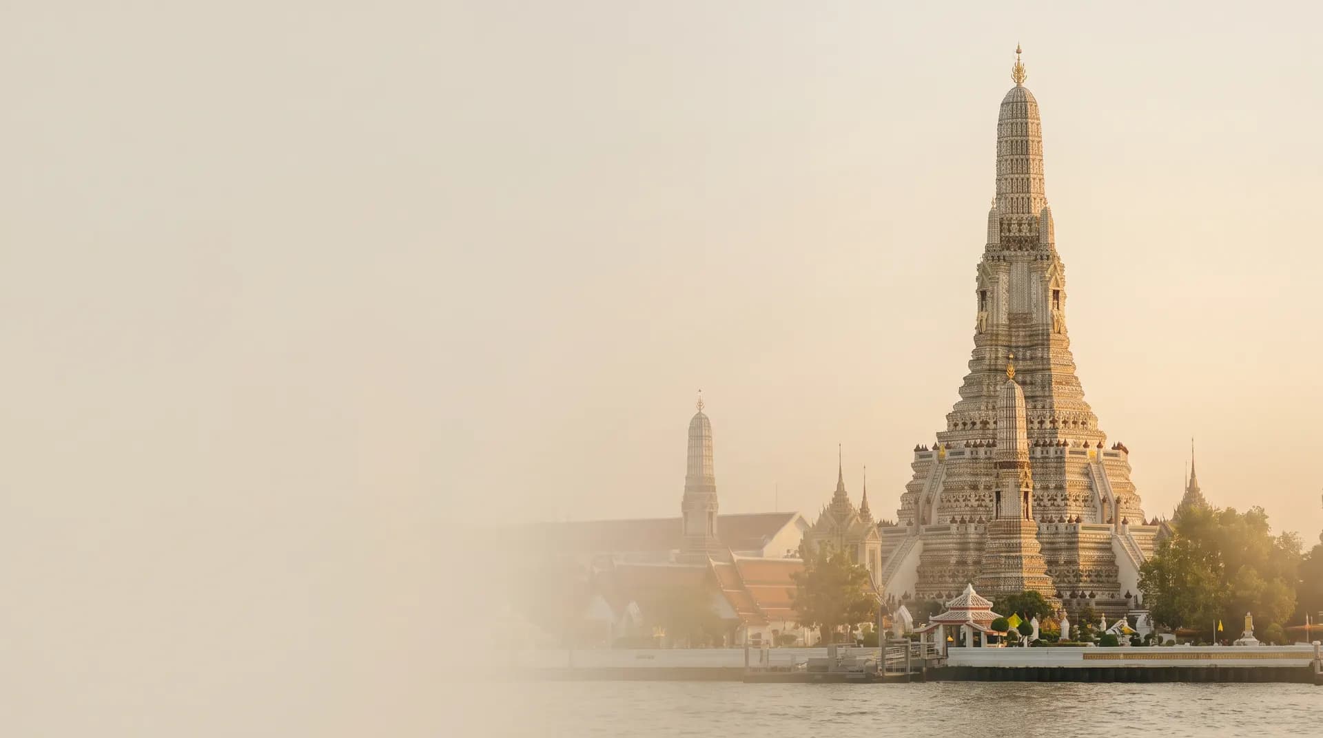 Wat Arun's ornate spire on the Chao Phraya river in Bangkok at golden hour